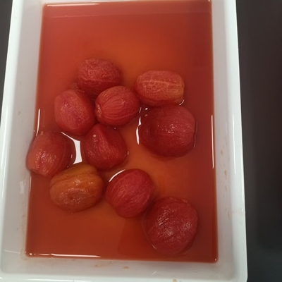 Deliciosos y dulces tomates enlatados y pelados con la materia prima más fresca