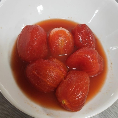 Deliciosos y dulces tomates enlatados y pelados con la materia prima más fresca